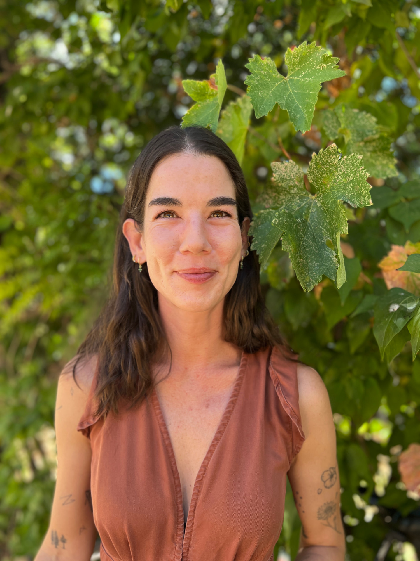 Portrait of Shirah Wagner standing in front of leafy green vines